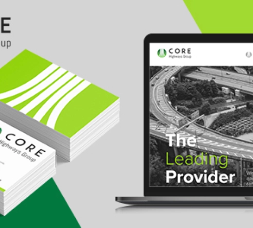 A laptop screen showing the new website design for Core Highways Group and a pile of business cards showing the new branding and logo Fabrick's creative team designed